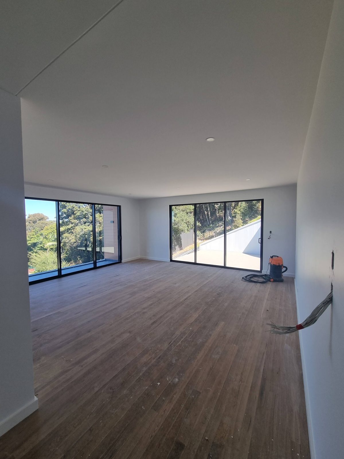 Freshly painted open living room with sliding doors to a leafy outlook